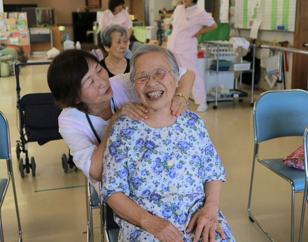 太宰府の施設での訪問ボランティアの様子。短い時間のふれあいでも笑顔がこぼれる。